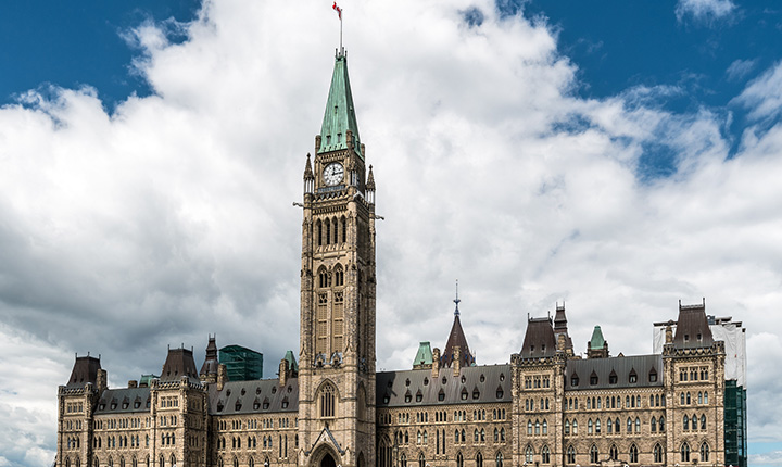 The parliament buildings in Ottawa standing in front of a blue sky