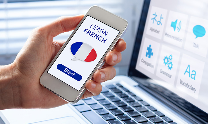 Hand hold phone with Learn French app screen on display